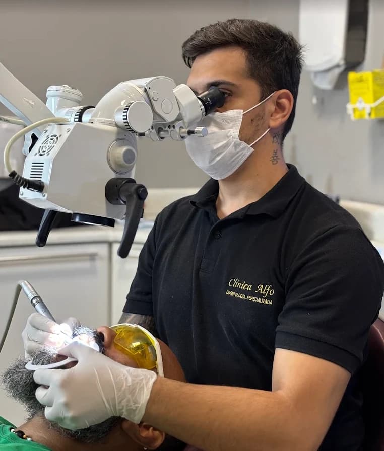 Dr. Renato Alfo em atendimento com microscópio odontológico
